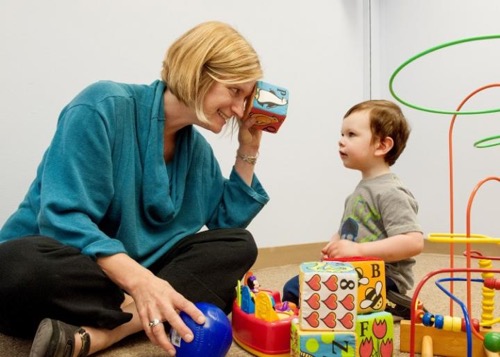 Annette Estes plays with 2-year-old Caellum Ortiz at the UW Autism Center