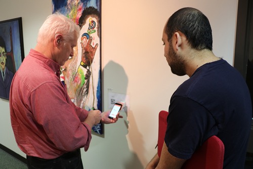 RIT/NTID faculty member Joseph Stanislaw discusses the museum accessibility app with Musab Al-Smadi