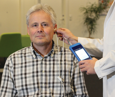 doctor and patient with hearing screening device