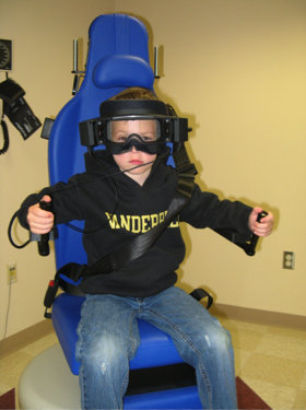 A child set up for testing using an open rotational chair system