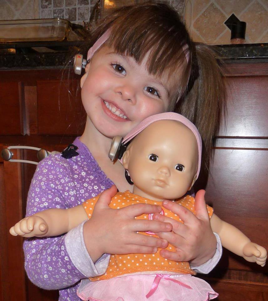 Ally and her doll both wearing their hearing devices