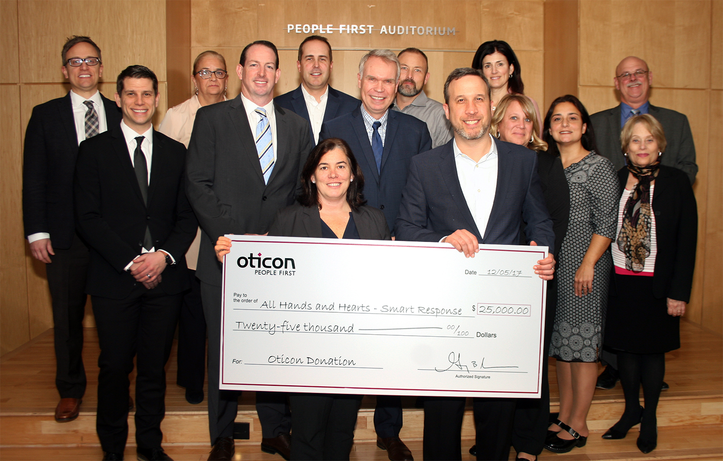 Oticon President Gary Rosenblum presents a check for $25,000 to Sara Hannafin