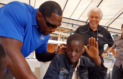 Ray Lewis and Bill Austin fit a patient with hearing aids at a Starkey mission in Tanzania