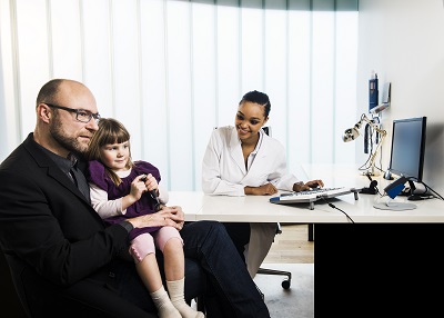 Doctor with young patient and her father
