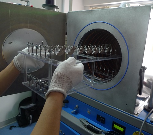 A tray of finished hearing instruments is loaded into a vacuum chamber where they will be nanocoated