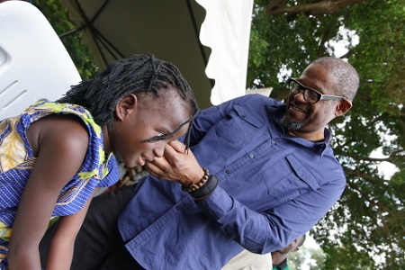 Forest Whitaker, Academy Award winner and UNESCO Goodwill Ambassador for Peace, fits a young girl with hearing aids at a Starkey Hearing Foundation mission