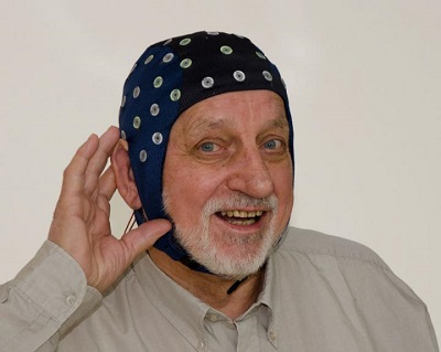 elderly man with brain scanning instrument