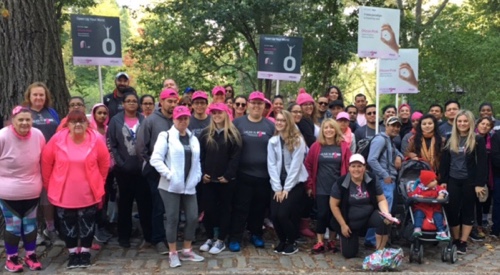 Oticon employees carrying “Hear in Pink” banners make every step count at the Making Strides Against Breast Cancer walk in NYC Central Park