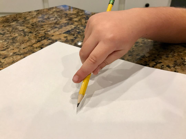 Child's hand demonstrating a Digital pronate pencil grasp
