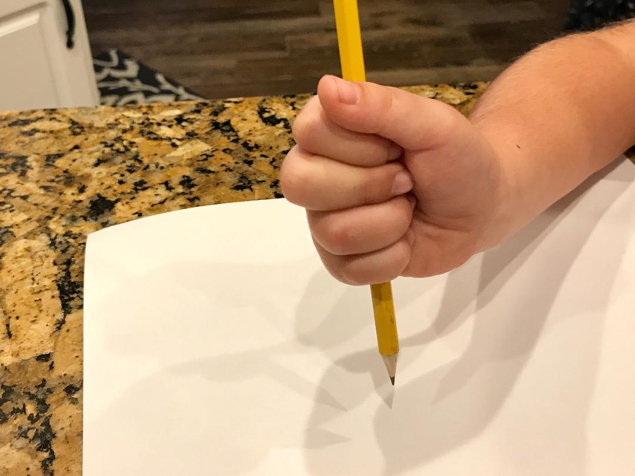 Palmer supinate pencil grasp demonstrated by a small child
