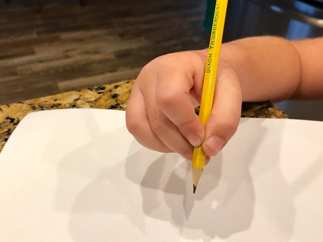 Tripod pencil grasp demonstrated by a small child