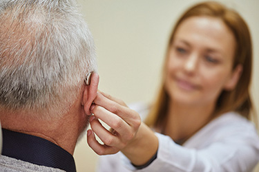 Provider adjusting a patient's hearing aid