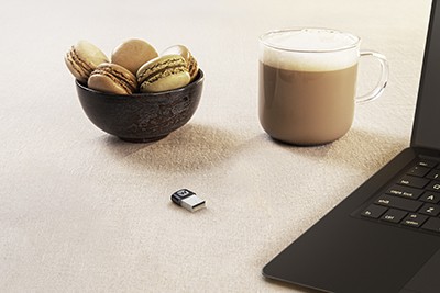 bowl with macarons, cup of coffee and soundconnect on a table with laptop