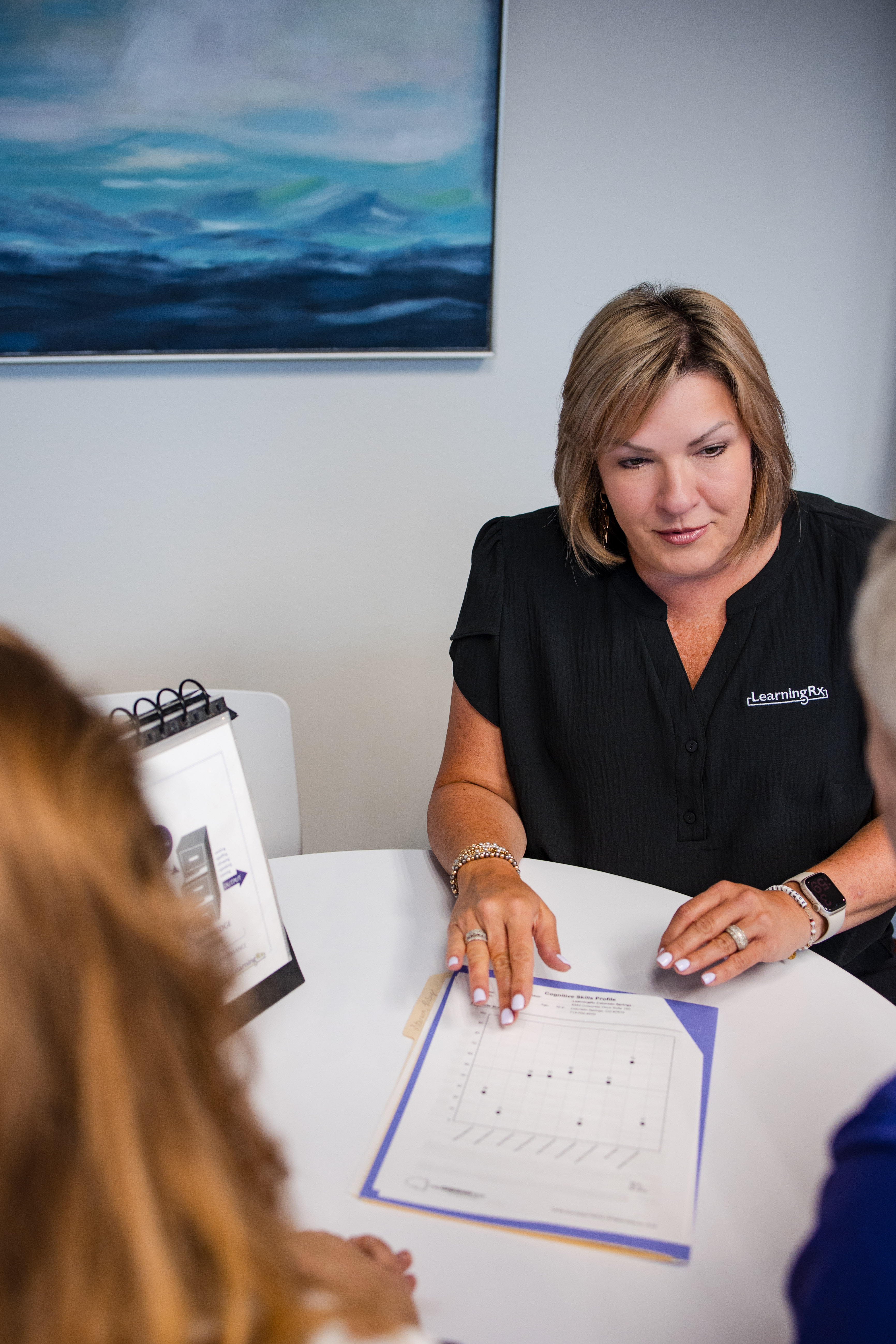 woman with paperwork talking to patients 